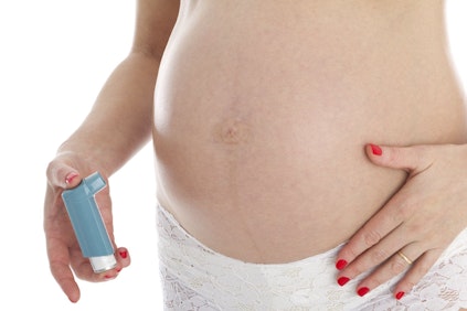 Pregnant woman holding an inhaler