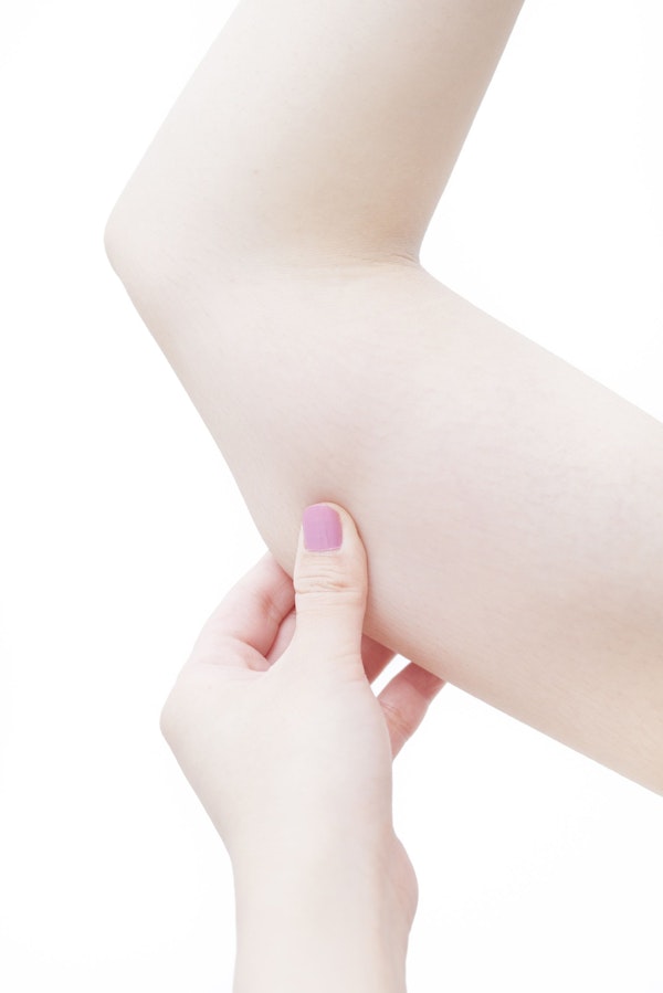 Woman pointing to upper arm