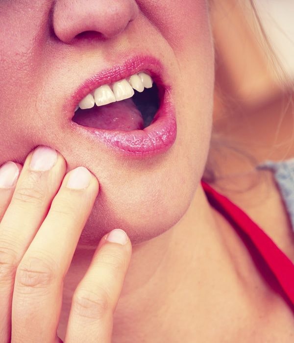 Close up of woman holding jaw in pain