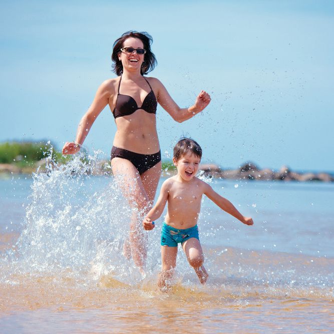 Photo of woman playing in water with small child