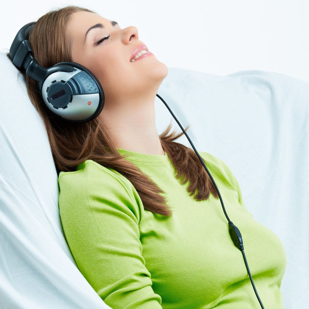 Woman looking relaxed while listening to music through headphones