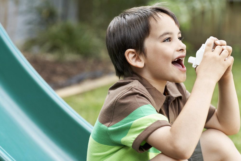Boy on a slide with his inhaler