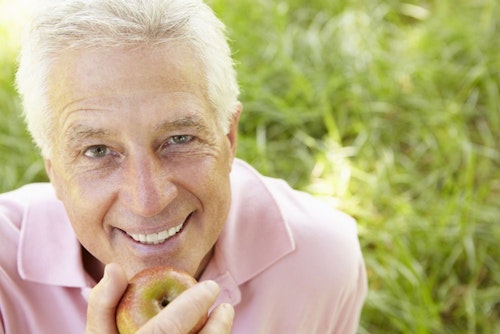 Smiling man holding apple