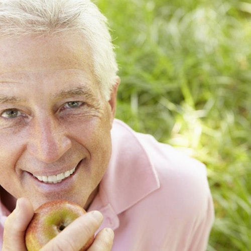 Smiling man holding apple