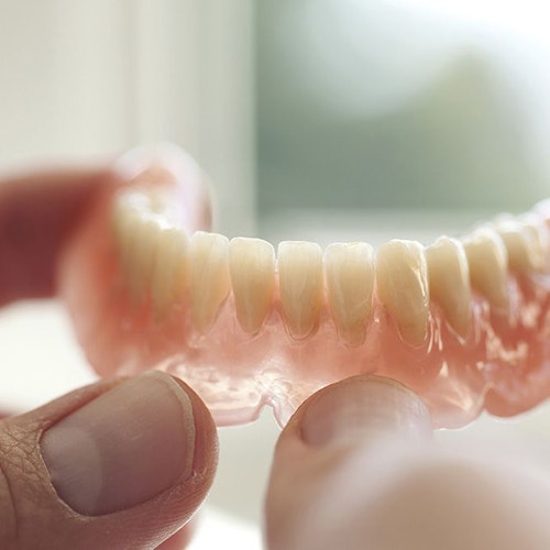 Dentures in a patient's hands.