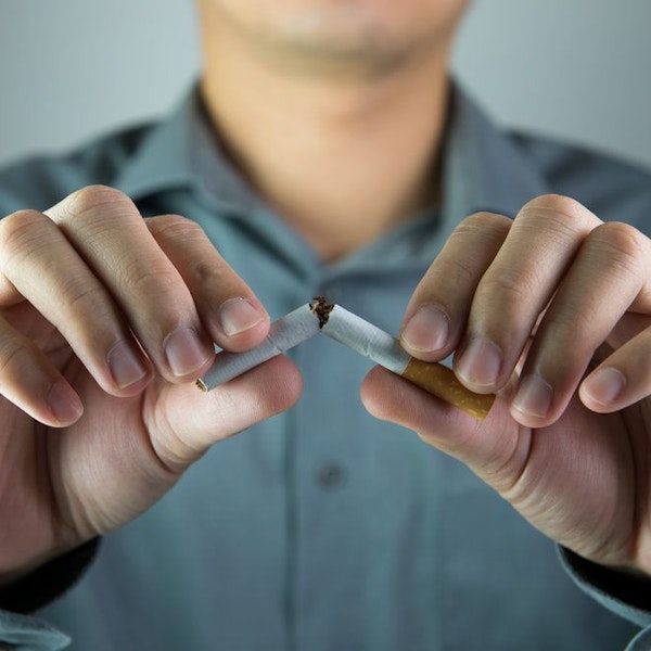 Person breaking cigarette in half