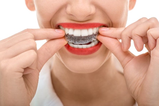 Woman putting in a clear plastic aligner