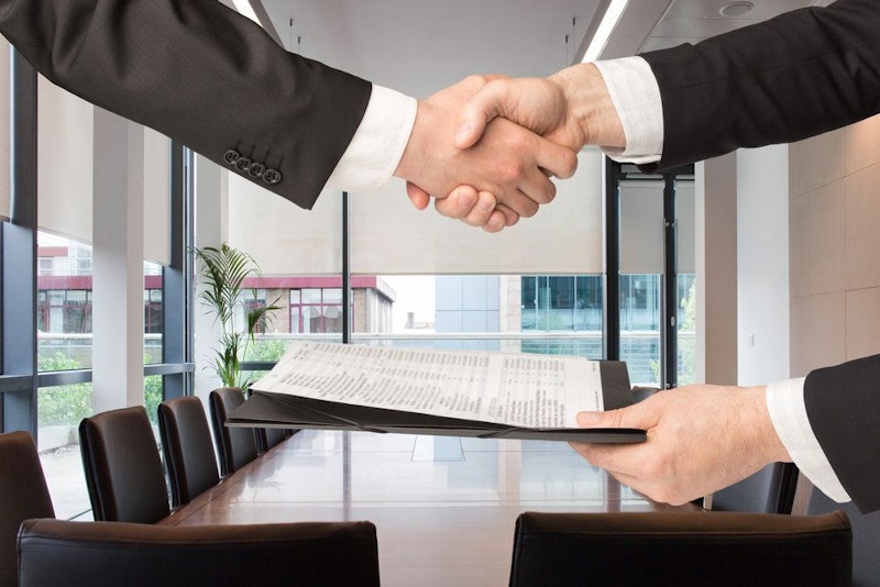 Hands shaking above a contract