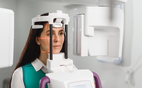 a woman standing in a cone beam scanner