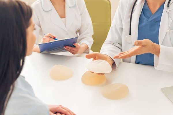 Doctor showing breast implant types