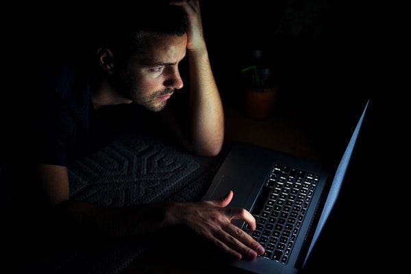 Man looking at his computer in the dark