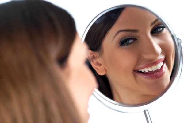 Woman smiling into mirror