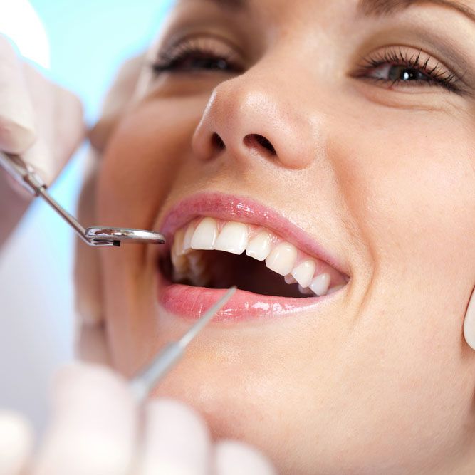 Smiling woman having her teeth inspected