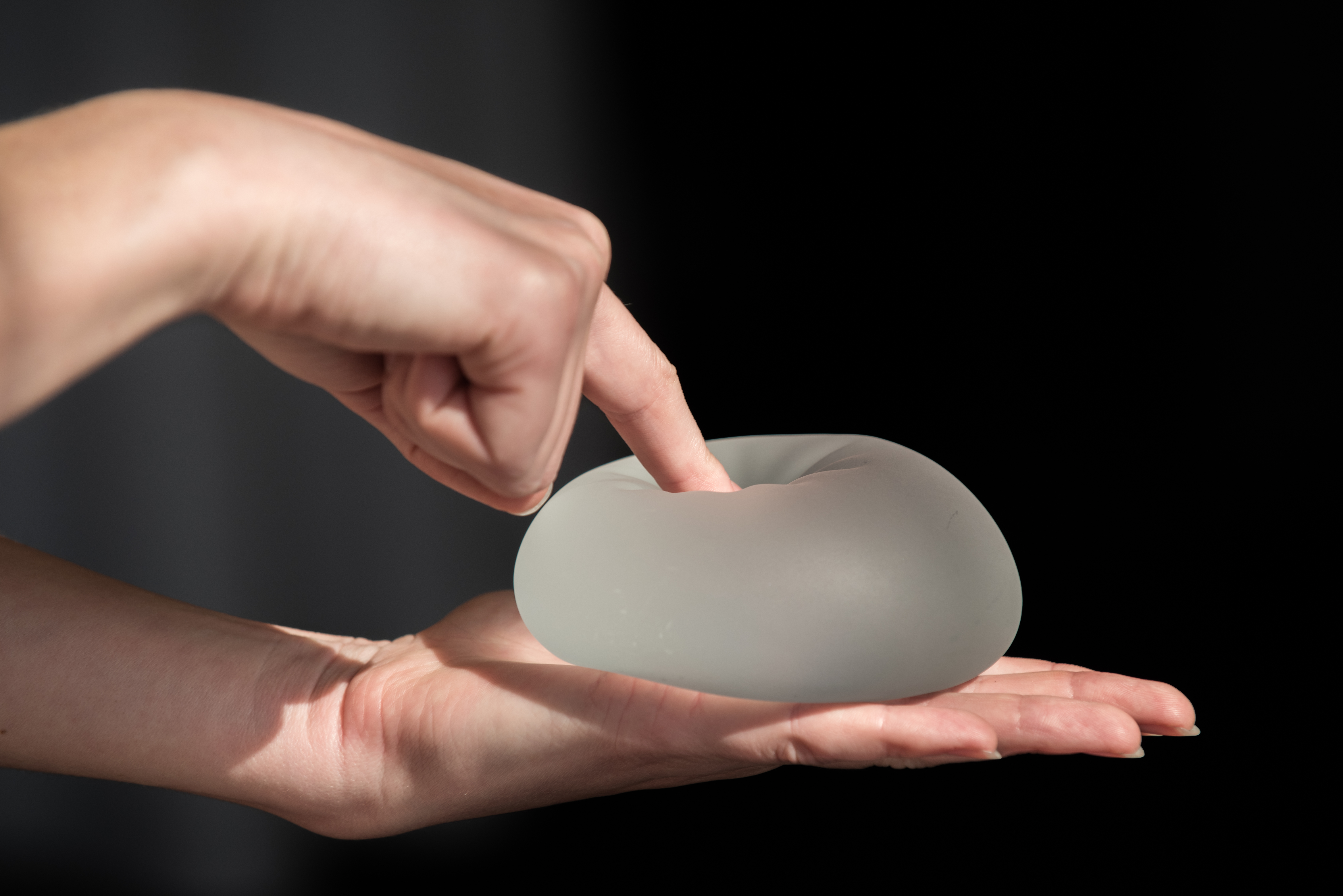 Person poking breast implant