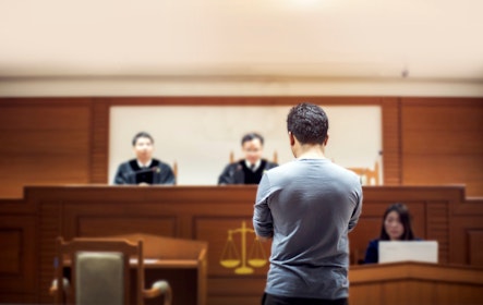 Man standing in front of bench in court