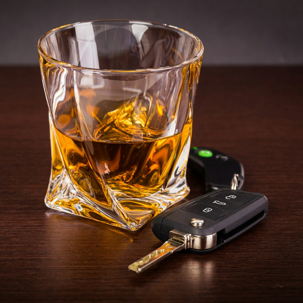 keys next to a glass of alcohol