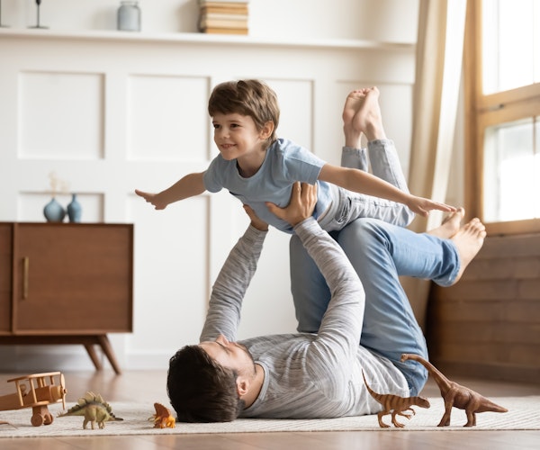 young boy and his father playing airplane