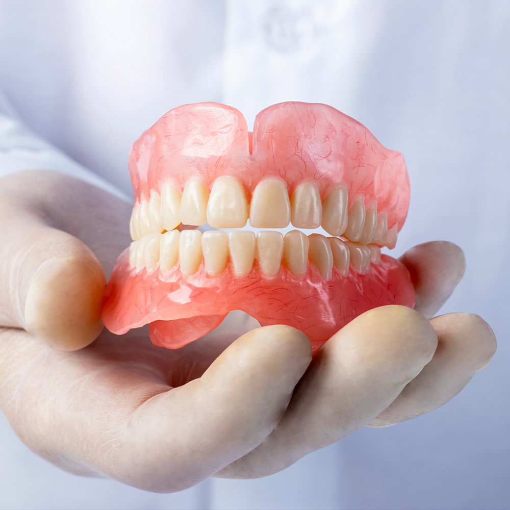 Dentist holding dentures