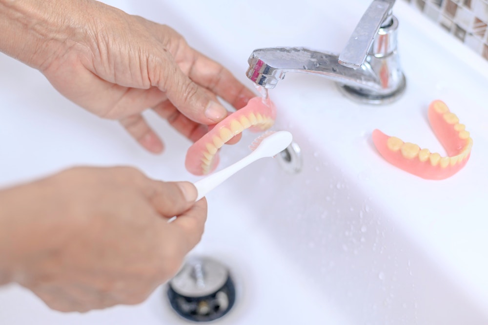 Cleaning dentures with toothbrush