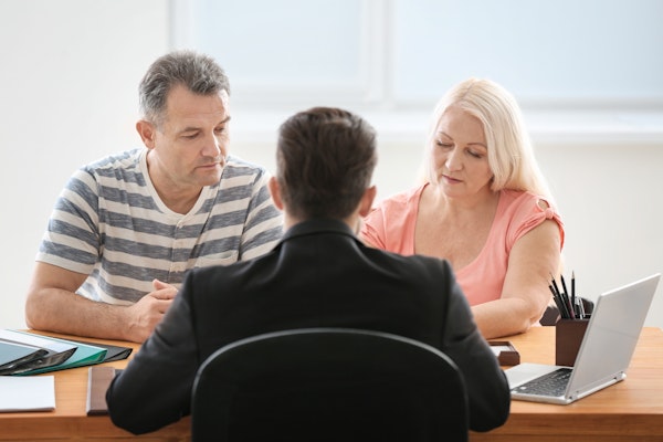 Older couple across desk from lawyer