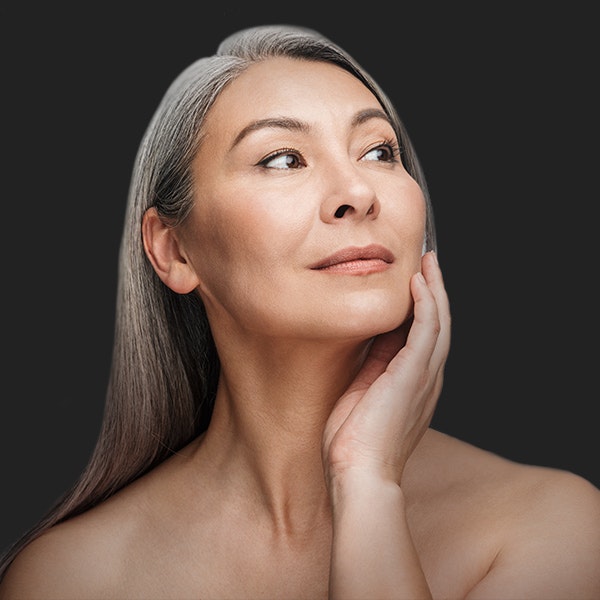 Older woman touching her face