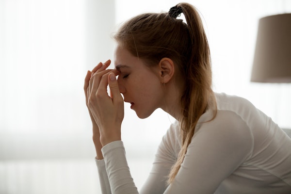 Woman with a headache touching her forehead