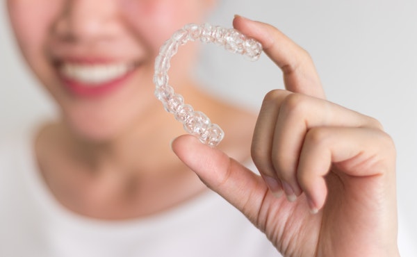 Woman holding clear aligner
