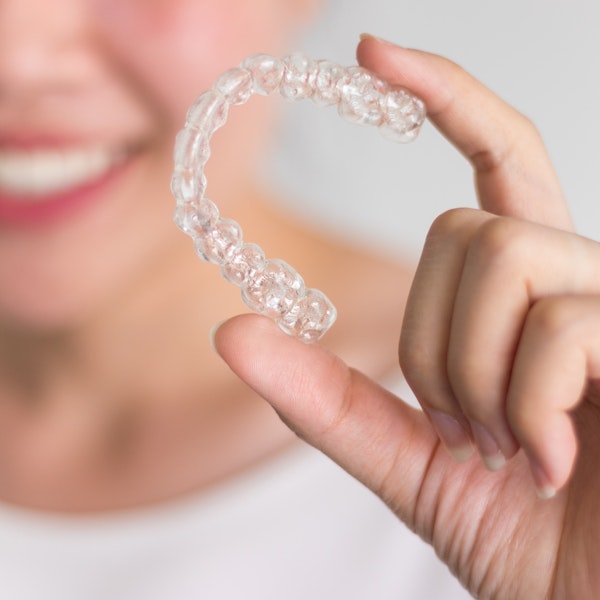 Woman holding clear aligner