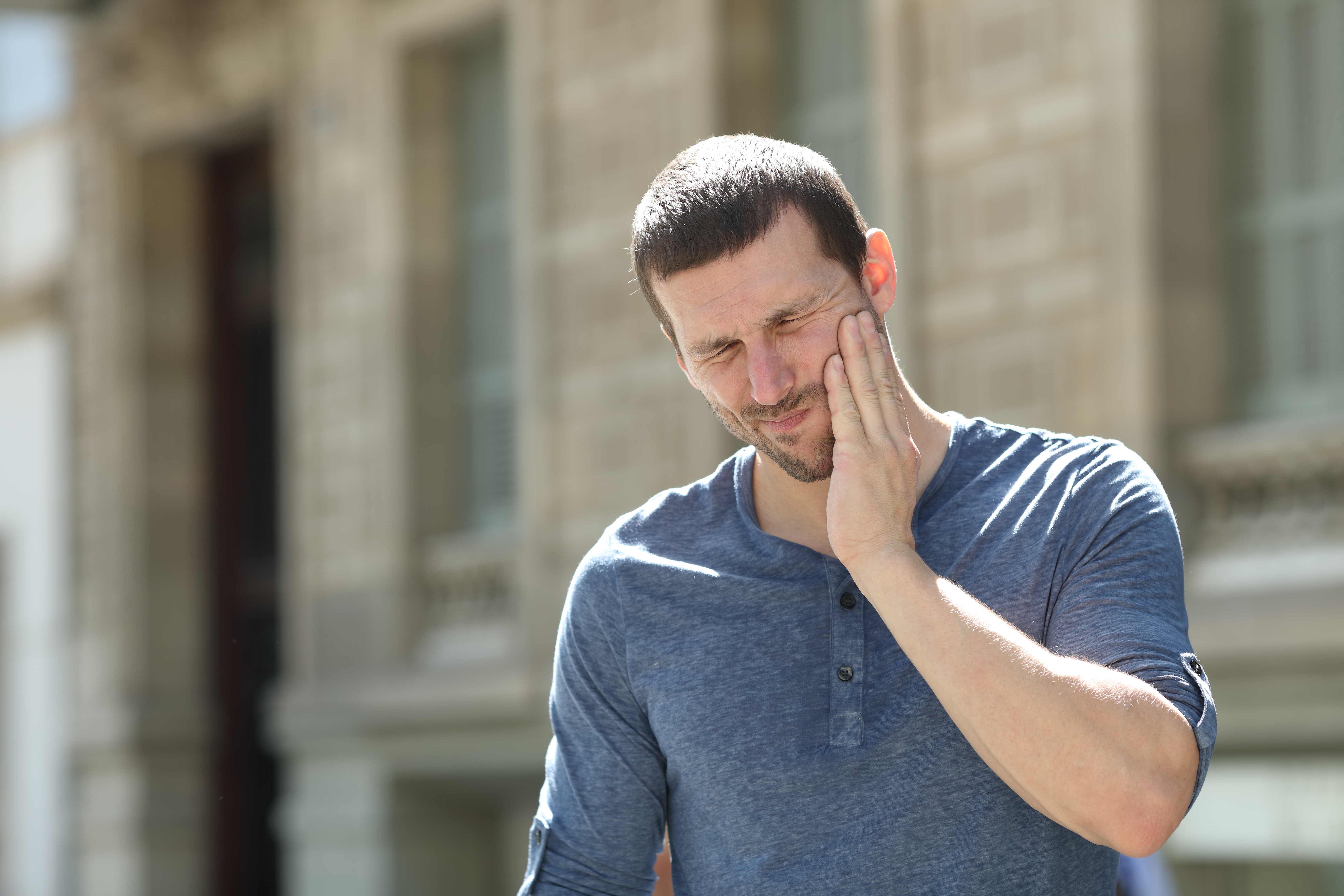 Man holding jaw in pain