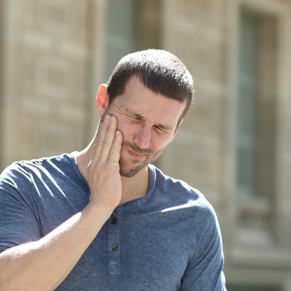 Man holding jaw in pain