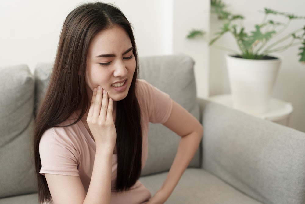 Woman holding jaw in pain