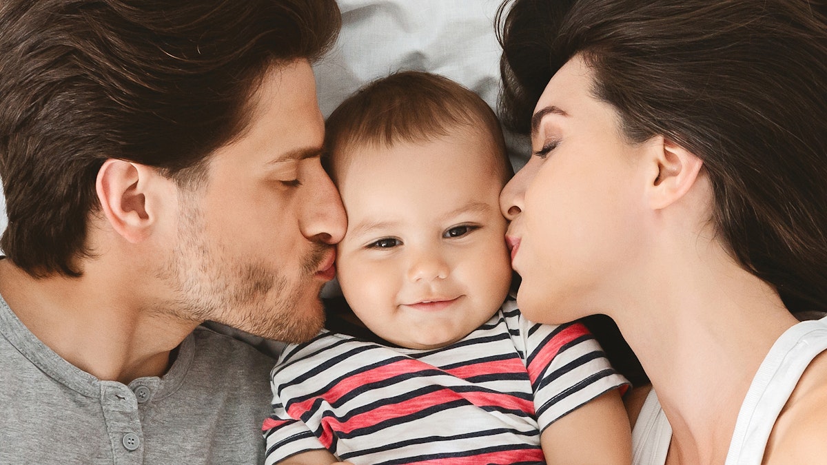 Parents kissing baby boy's cheeks