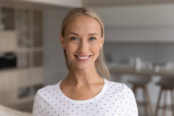 A beautiful, young woman with straight blond hair showing off a beautiful smile