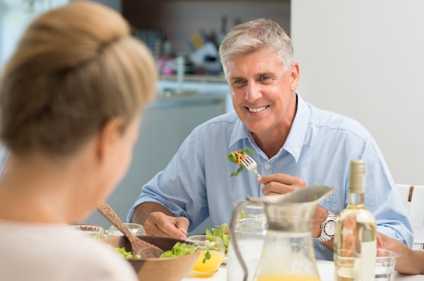 Mature man smiling while eating