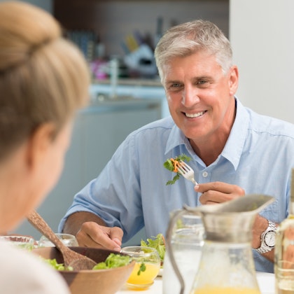 Smiling man eating salad