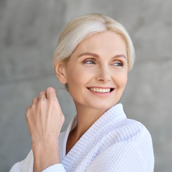 Mature woman in bathrobe smiling