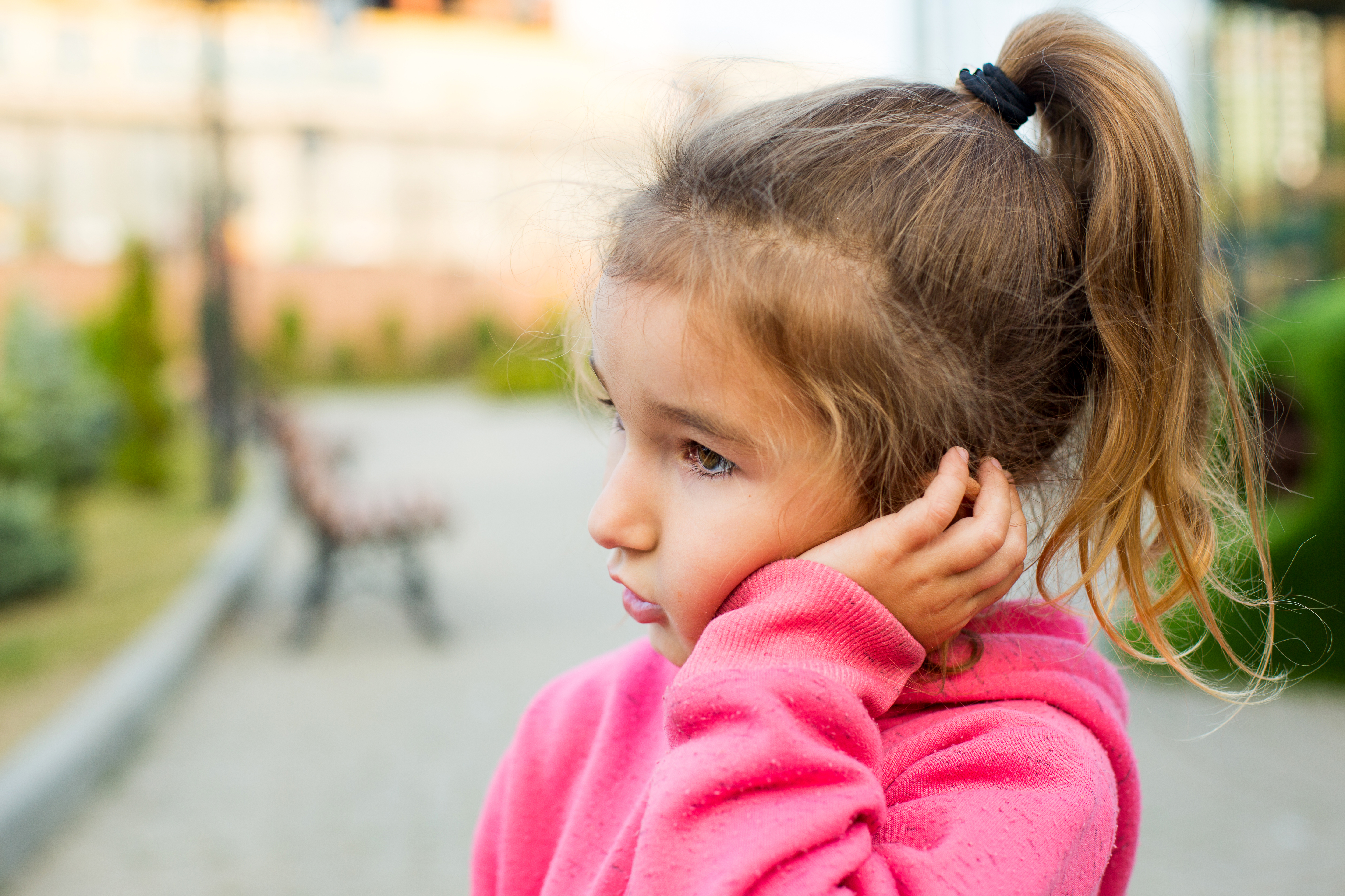 Little girl holding cheek in pain