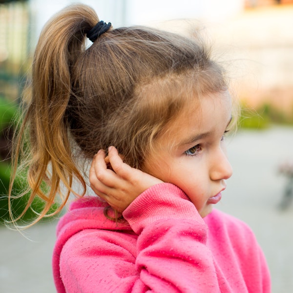 Little girl holding cheek in pain