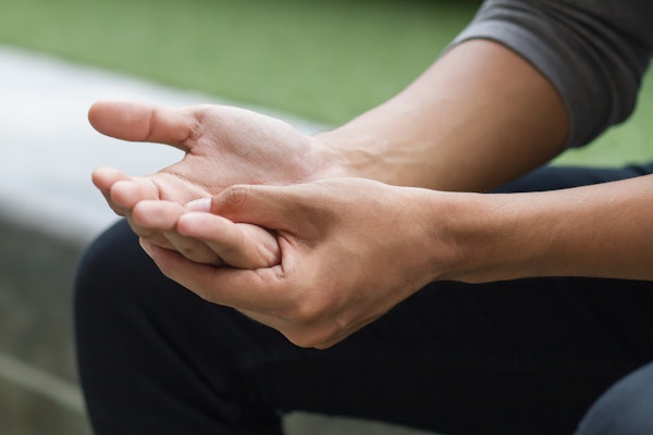 Person gripping hand in pain