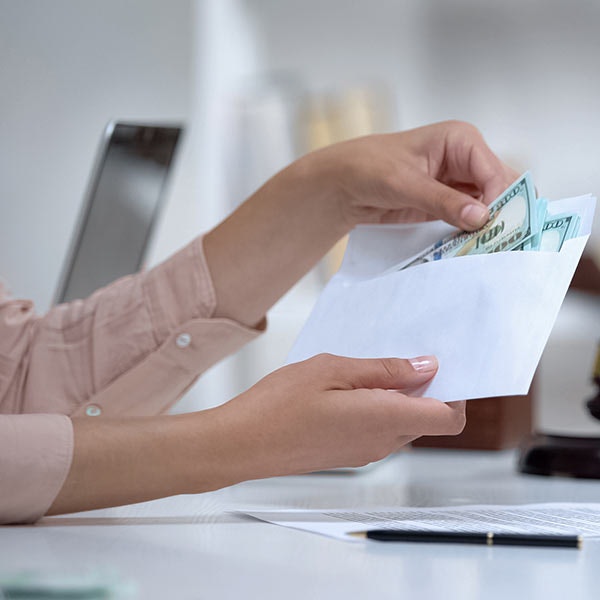 Woman opening envelope with money inside