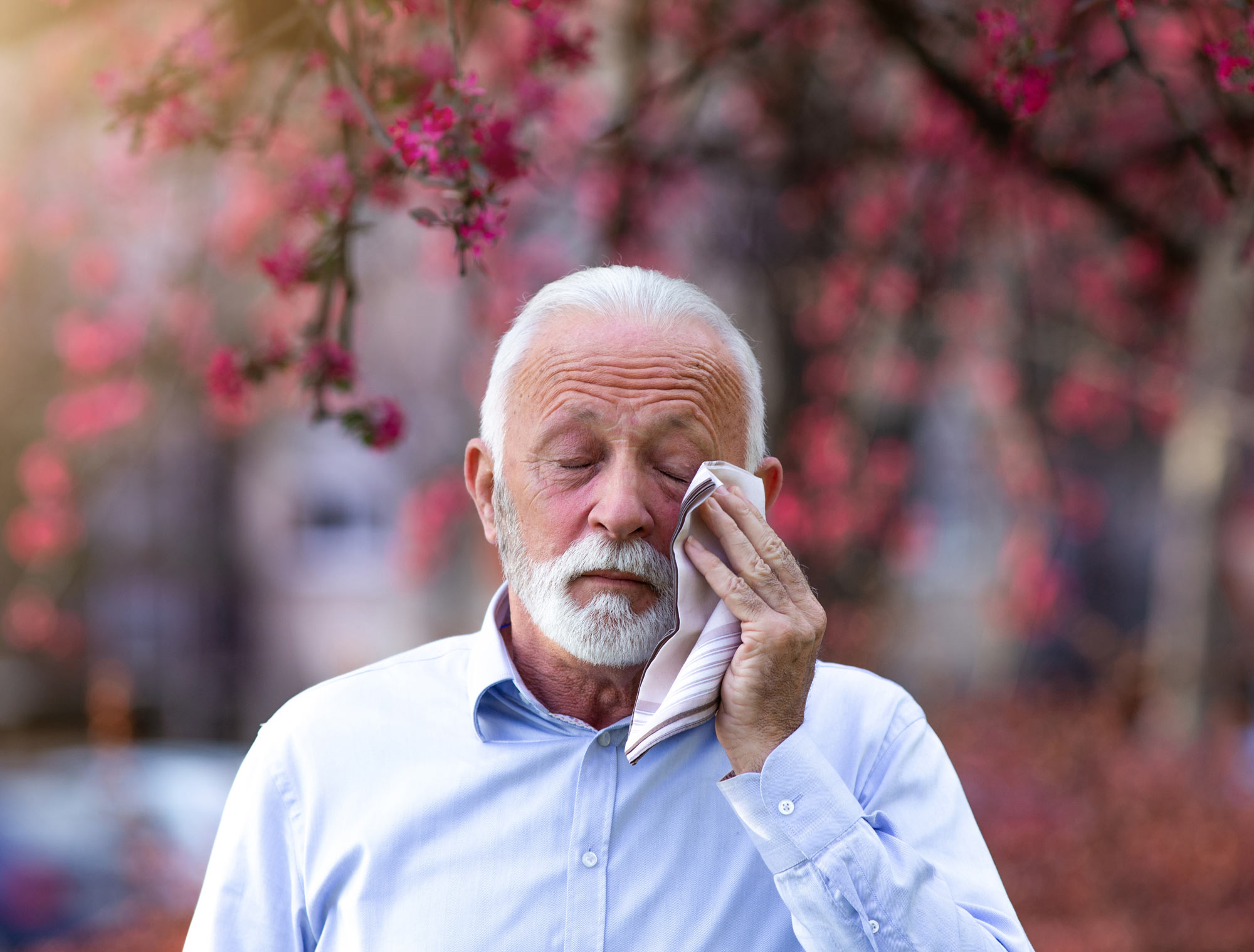 man wiping his eye with a handkerchief 