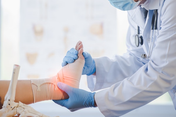 Doctor wrapping a patient's ankle after an injury