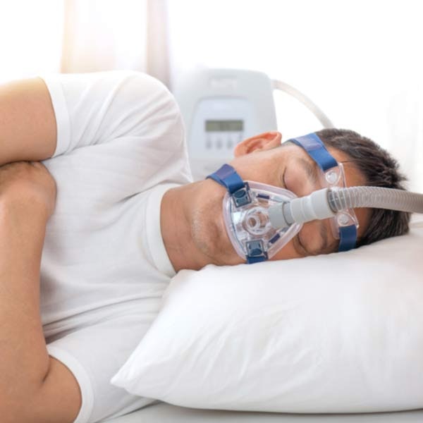 Man in bed with wearing CPAP mask