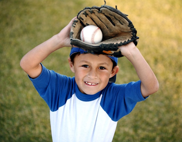 Young boy holding baseball in baseball glove