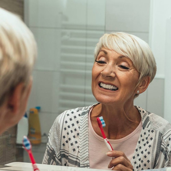 Mature woman brushing teeth