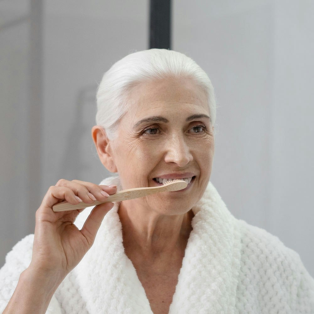 Mature woman brushing teeth