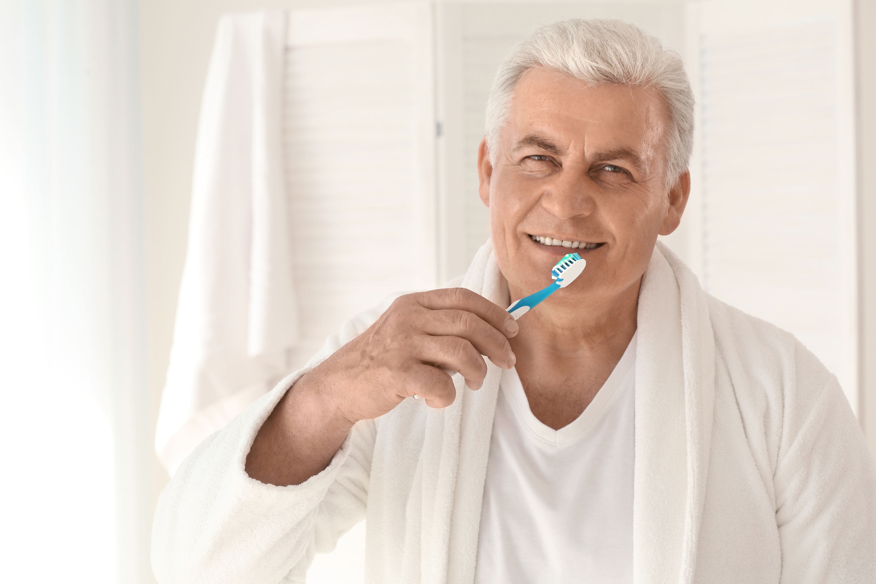 Mature man brushing teeth