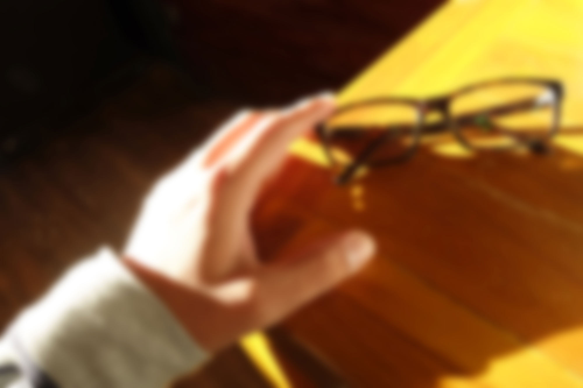 Blurry vision of person reaching for glasses