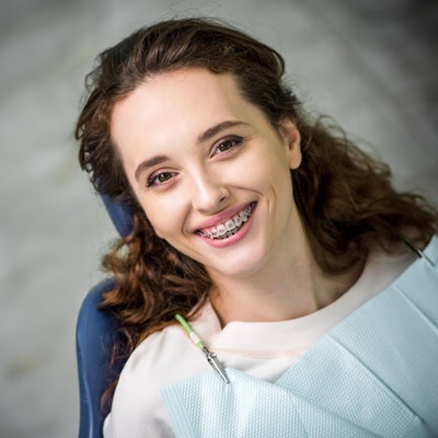 smiling woman wearing clear braces outdoors