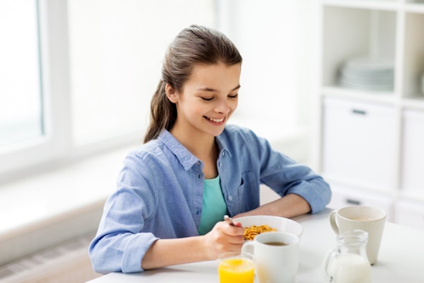 Young teenager eating breakfast